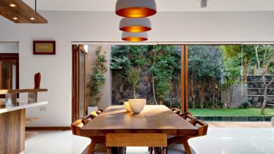 Belle salle à manger avec une table en bois et de belles suspensions luminaires