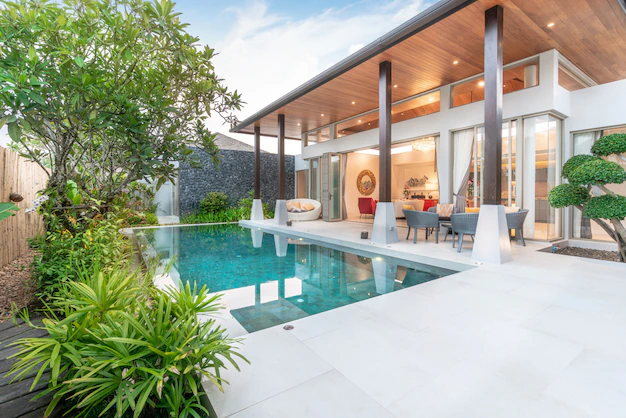 Belle terrasse moderne ayant pour revêtement de sol les carreaux de couleur blanche accompagné d'une belle piscine et d'un mobilier chic