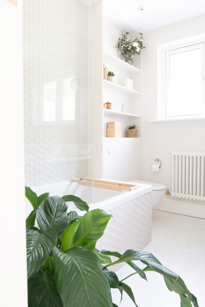 Salle de bain de couleur blanche avec de très belles étagères pour plus de rangements.