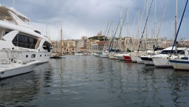 Vue panoramique du Vieux-Port de Marseille avec yachts de luxe amarrés et immeubles résidentiels de standing en arrière-plan, illustrant la fusion entre tradition maritime et modernité digitale dans le secteur immobilier marseillais.